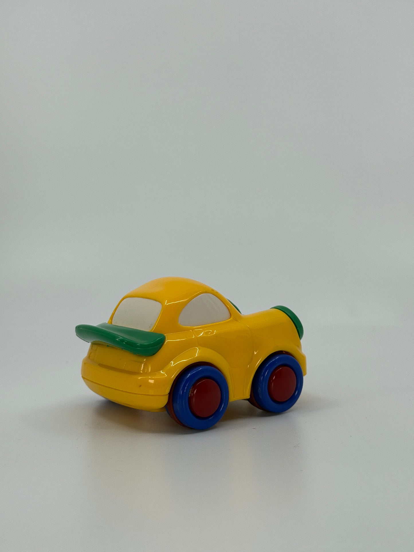 Kollane mänguauto värviliste ratastega