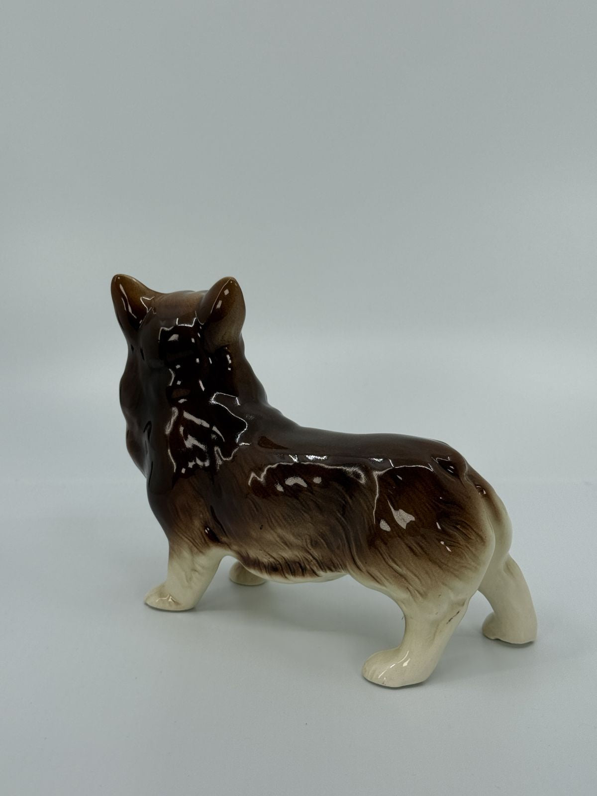 Keraamiline pruuni-valge koera figuur